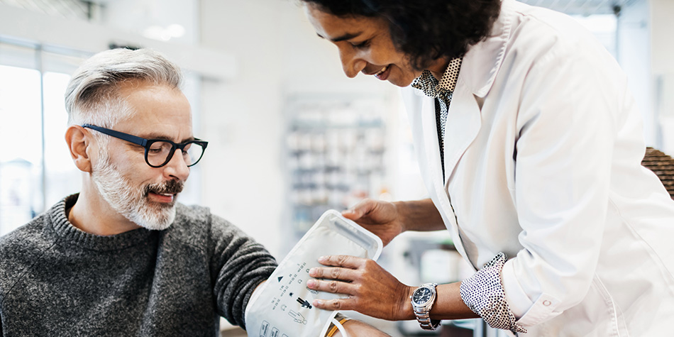 Pharmacist Measuring Mature Man's Blood Pressure